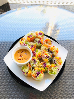 A picture of Rainbow Vegetables Rolls with Peanut Sriracha Dipping Sauce.