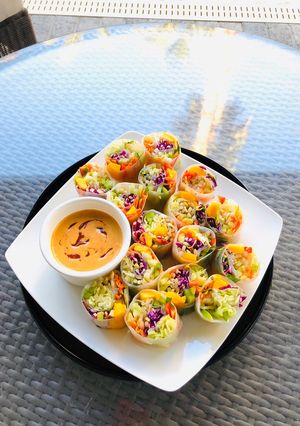 A picture of Rainbow Vegetables Rolls with Peanut Sriracha Dipping Sauce.