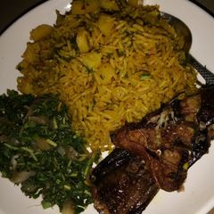 A picture of Jollof Rice and Irish with vegetable Sauce and Cat Fish.