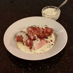 A picture of Roast Pork Tenderloin wrapped with Pastrami and served with a Romano / Marscapone Cream Sauce.