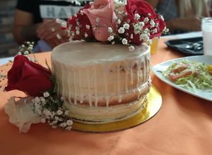 Una foto de Naked cake de vainilla y fresa con drip de chocolate blanco
