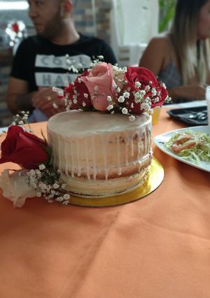 Una foto de Naked cake de vainilla y fresa con drip de chocolate blanco