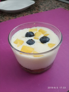 Una foto de Yogurt de mango y arándanos