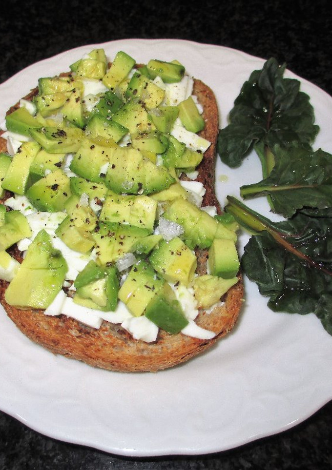 Una foto de Rebanas de pan rústico integral tostado con queso fresco tradicional y aguacate
