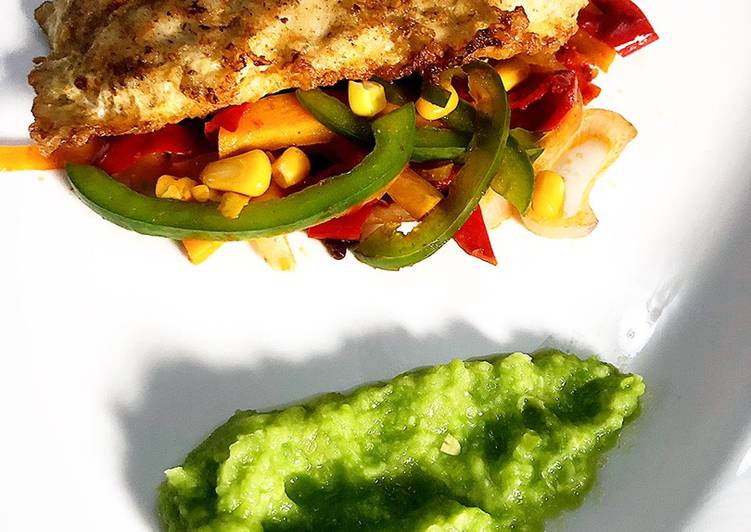 Deep fried fish fillet on a bed of sautéed vegetables & pea purée