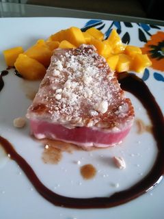 Una foto de Atún con costra de parmesano, guarnición de mango y salsa agridulce de ostión