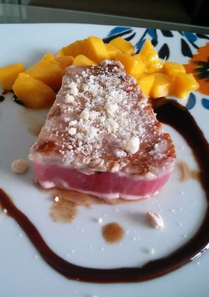 Una foto de Atún con costra de parmesano, guarnición de mango y salsa agridulce de ostión