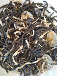 Una foto de Spaguettis negros con gulas, gambas y almejas
