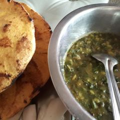 A picture of Palak ka saag with makki ki roti and mooli ki sabzi.