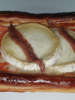 Una foto de Hojaldre con queso de cabra, tomate y anchoas