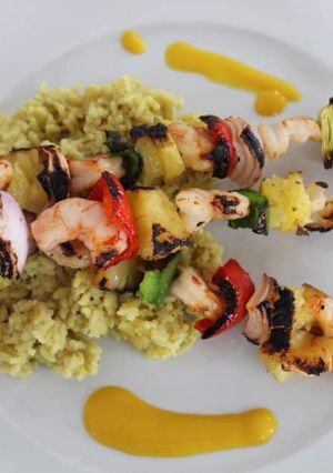 Una foto de Pinchos de camarones y ananá con arroz cremoso de curry y salsa de mango & habanero