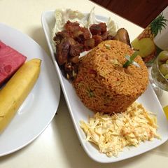A picture of Jollof rice with salad, pepper kpomo and fried chicken.