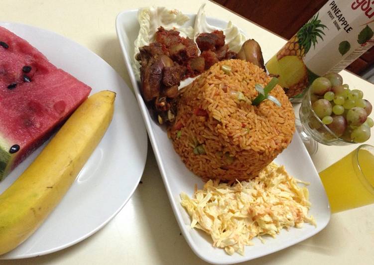 Jollof rice with salad, pepper kpomo and fried chicken