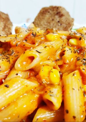 A picture of Orange Penne Pasta with Crispy Herb Bread.