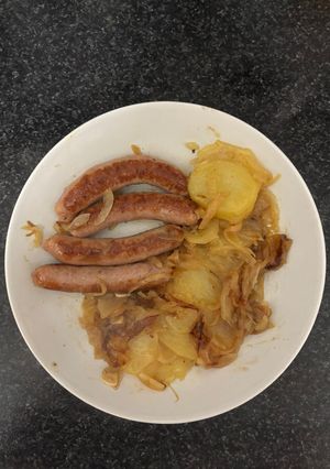 Una foto de Salchichas con cebolla al vino blanco con acompañamiento de patatas panaderas