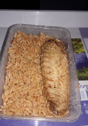 A picture of Home cooked jollof rice with fried Turkey.