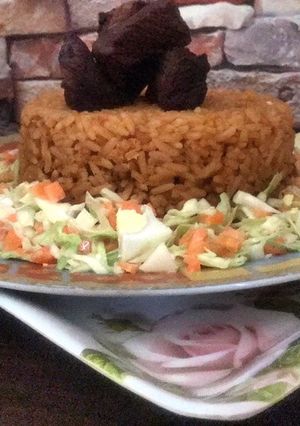 A picture of Beef Jollof rice with coleslaw.