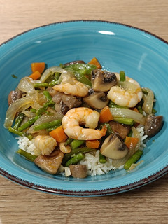 Una foto de Wok de langostinos salteados con champiñones y trigueros