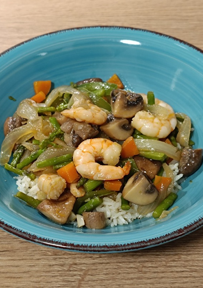 Una foto de Wok de langostinos salteados con champiñones y trigueros