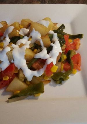 Una foto de Papas blancas con rajas de poblano y granos de elote