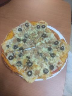 Una foto de Pizza de atún, aceitunas negras y cebolla frita