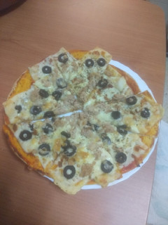 Una foto de Pizza de atún, aceitunas negras y cebolla frita