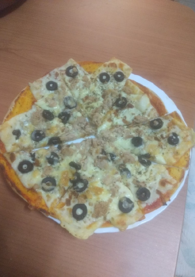 Una foto de Pizza de atún, aceitunas negras y cebolla frita
