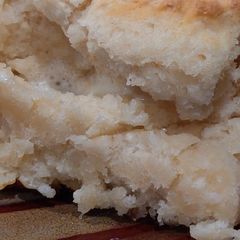 A picture of Simple Buttermilk Biscuits Dipped in Some Butter.
