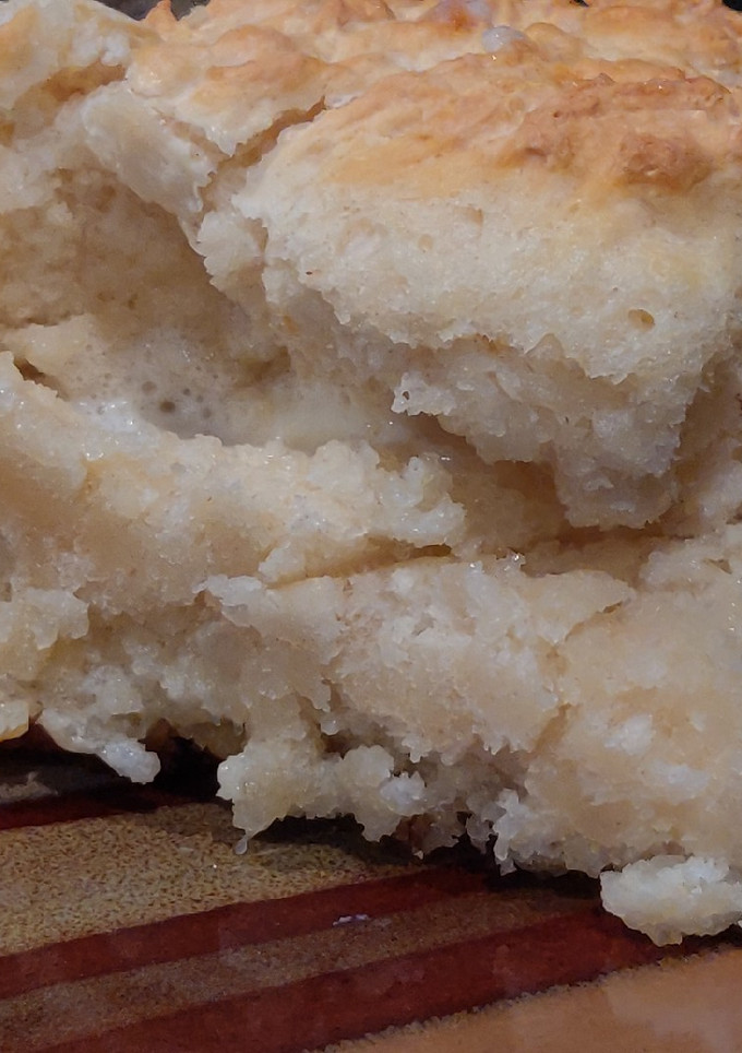 A picture of Simple Buttermilk Biscuits Dipped in Some Butter.