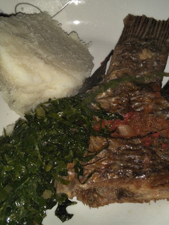 A picture of Fried fish with greens and ugali.