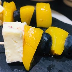 A picture of Fruit and cheese sticks.