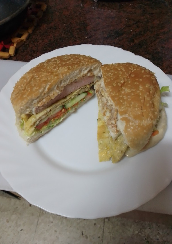 Una foto de Hamburguesa de pollo, tortilla francesa, queso curado y mayonesa de cebolla