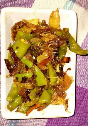 A picture of Fried chilli with onion and raw mango.