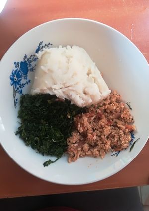 A picture of Scrambled eggs with ugali and kales.