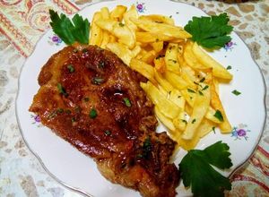 O poză a rețetei Ceafă de porc la cuptor cu cartofi prăjiți.