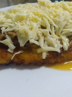 Una foto de Patacón con carne desmechada en salsa y queso