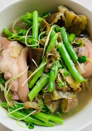 Hình của món Canh chân giò hầm với cà tím, đậu ve, và rau cải mầm.
