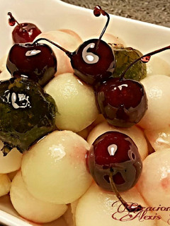 Una foto de Bolitas de melón, con confitura de menta y cerezas confitatas