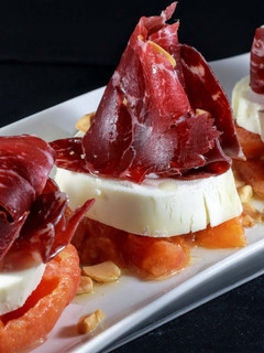 Una foto de Tomate confitado, queso de cabra y cecina