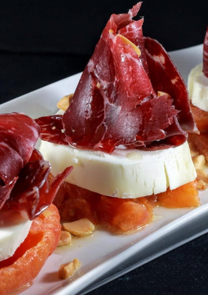 Una foto de Tomate confitado, queso de cabra y cecina