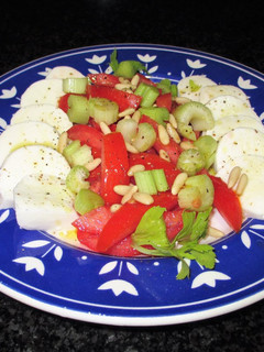 Una foto de Mozzarella de búfalo con tomates, pencas de apio y piñones