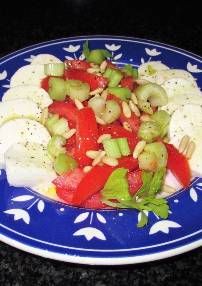 Una foto de Mozzarella de búfalo con tomates, pencas de apio y piñones