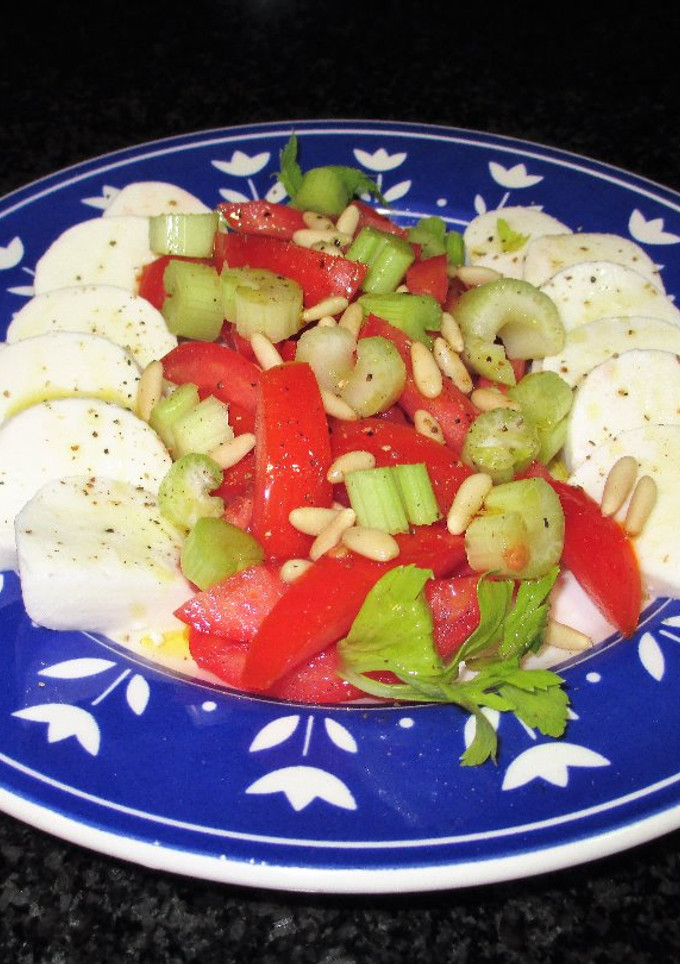 Una foto de Mozzarella de búfalo con tomates, pencas de apio y piñones
