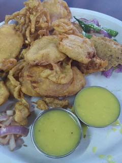 A picture of Varieties of pakoda with chutney.