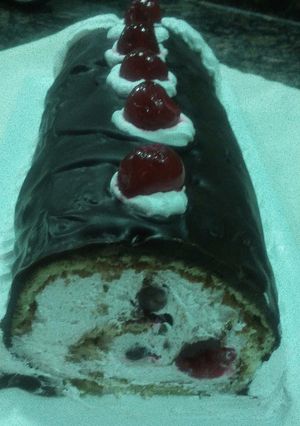 Una foto de Tronco de crema, cerezas y chocolate