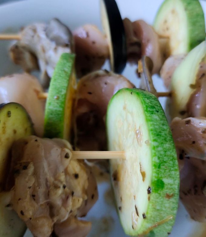 Фото Курячі шашлички з овочами на шпажках над пательнею.