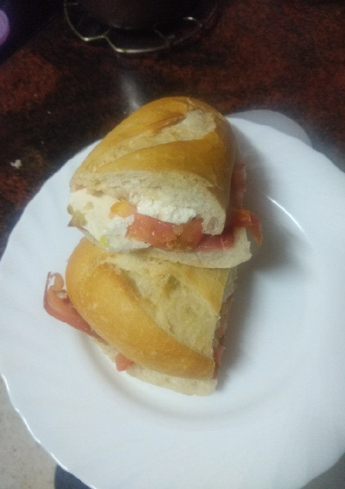 Una foto de Bocadillo de jamón serrano, lascas de queso tierno y tomate