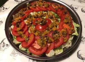 Une photo de Salade iceberg et tomates aux raisins marinés sauce tomates séchées