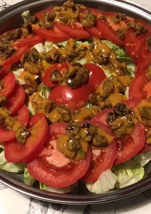 Une photo de Salade iceberg et tomates aux raisins marinés sauce tomates séchées