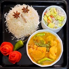A picture of Chicken gravy and boiled rice with peach drink.